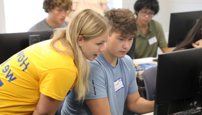 Peer mentor helping student on the computer