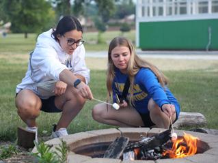 Two Students Roasting Marshmallows at a campus firepit