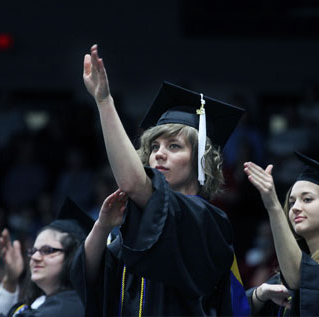 sign language studies student in cap and gown performing the national anthem 
